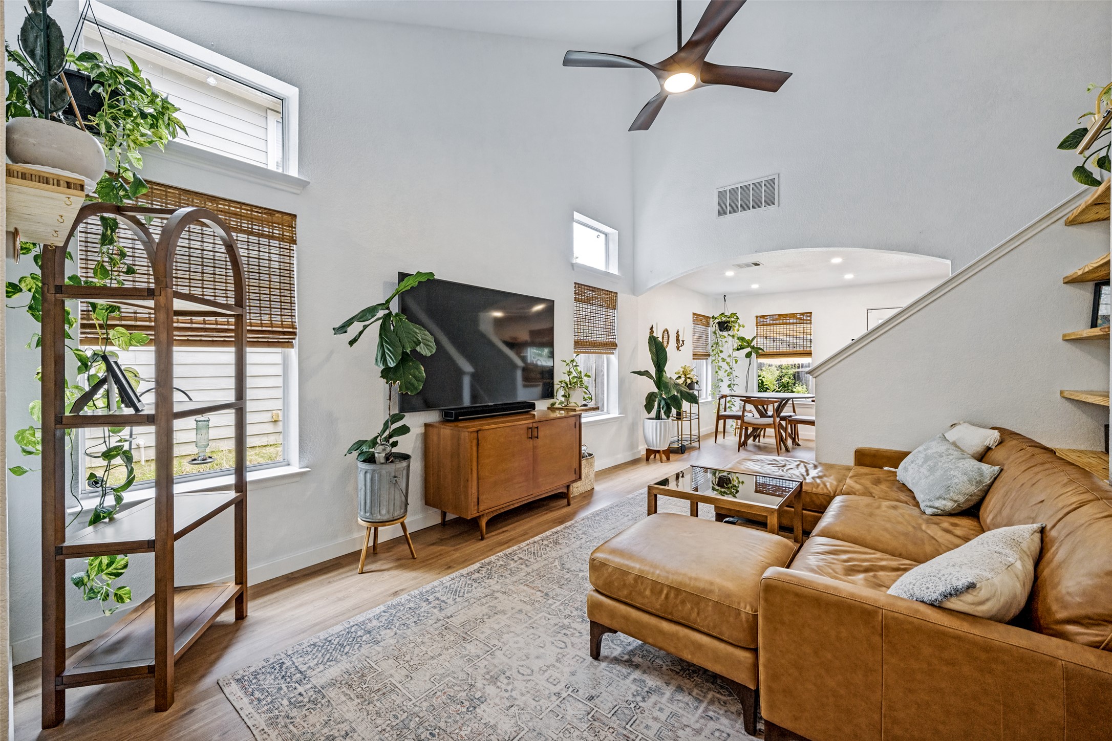 Natural light bathes this lofty living area, highlighting warm wood floors and high ceilings.