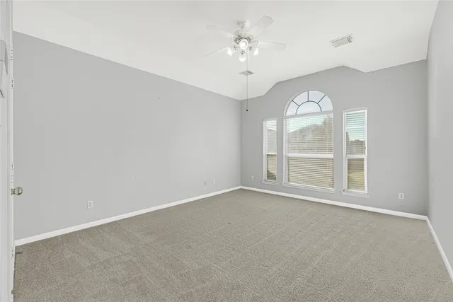 a view of a room with a ceiling fan and wooden floor