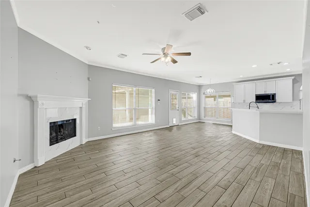 a view of an empty room with window and wooden floor
