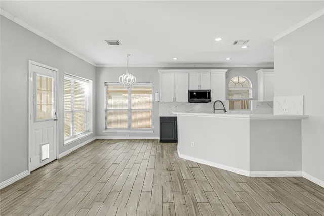 a large kitchen with a large counter top space appliances and cabinets