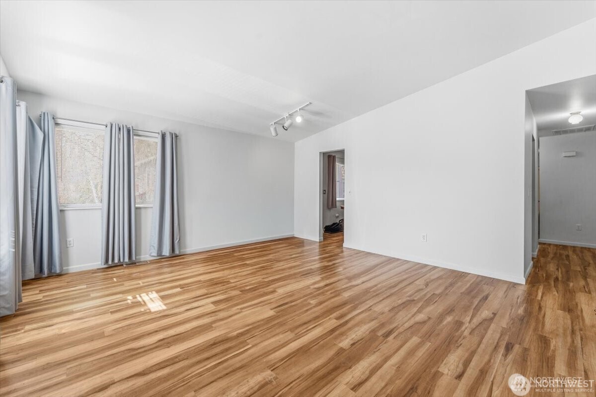 380 North Shore Court Manson, WA 98831 - Photo 7 of 27 a view of an empty room with wooden floor and a window