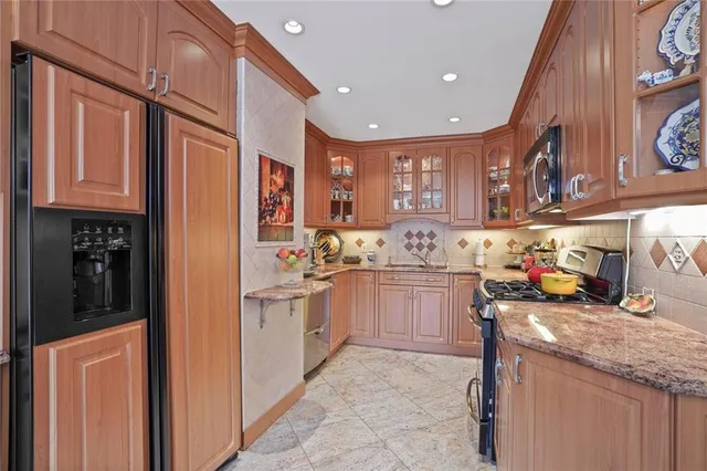 a kitchen with stainless steel appliances granite countertop a sink and cabinets