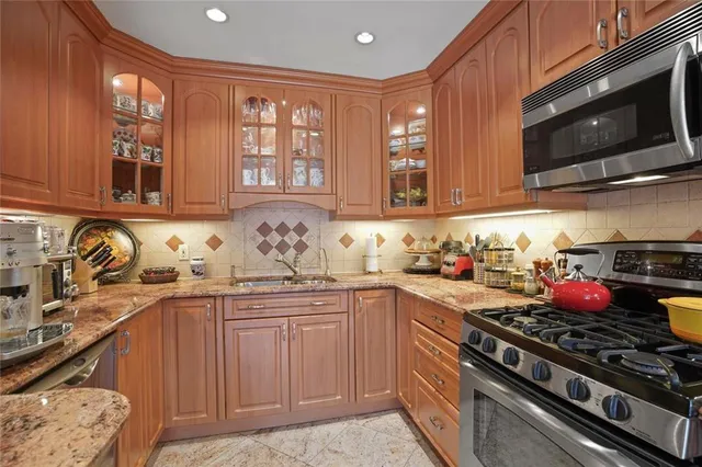 a kitchen with stainless steel appliances granite countertop a sink stove and microwave