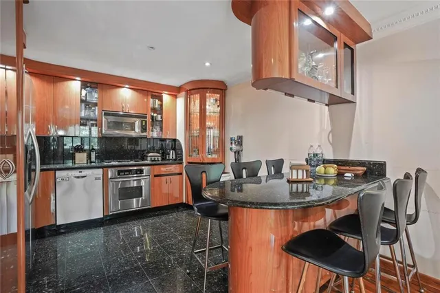 a kitchen with stainless steel appliances granite countertop a stove a sink and a refrigerator