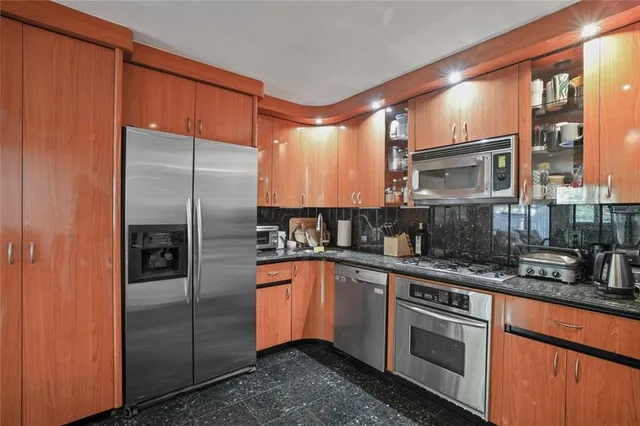 a kitchen with stainless steel appliances granite countertop a refrigerator and a sink