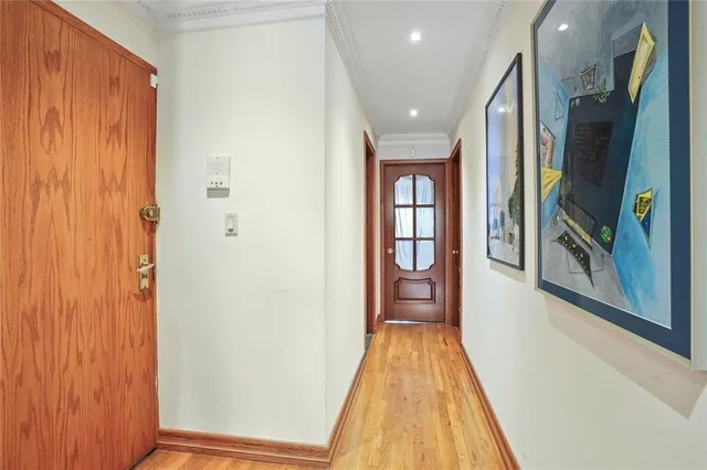 a view of a hallway with wooden floor and glass door