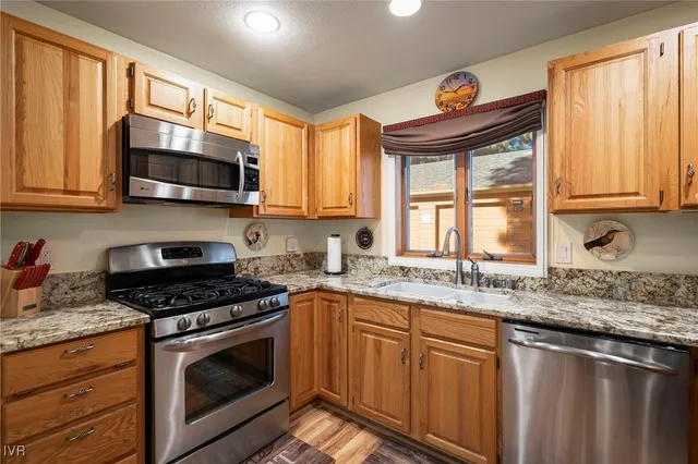 a kitchen with stainless steel appliances granite countertop a stove a sink and a microwave