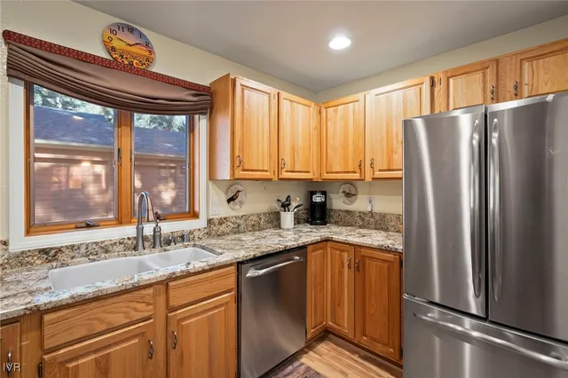 a kitchen with stainless steel appliances granite countertop a refrigerator and a sink