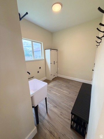 450 13800 South, Unit 2 Draper, UT 84020 - Photo 18 of 21 Laundry area with wood-finish flooring, a utility sink with a black wall-mounted faucet, and a window providing natural light