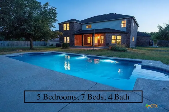 a view of a house with swimming pool and yard