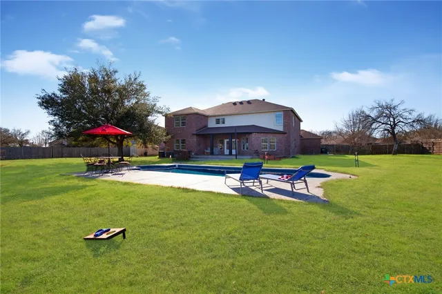 a view of a swimming pool of a house with a yard