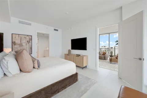 a spacious bedroom with a bed and a lamp