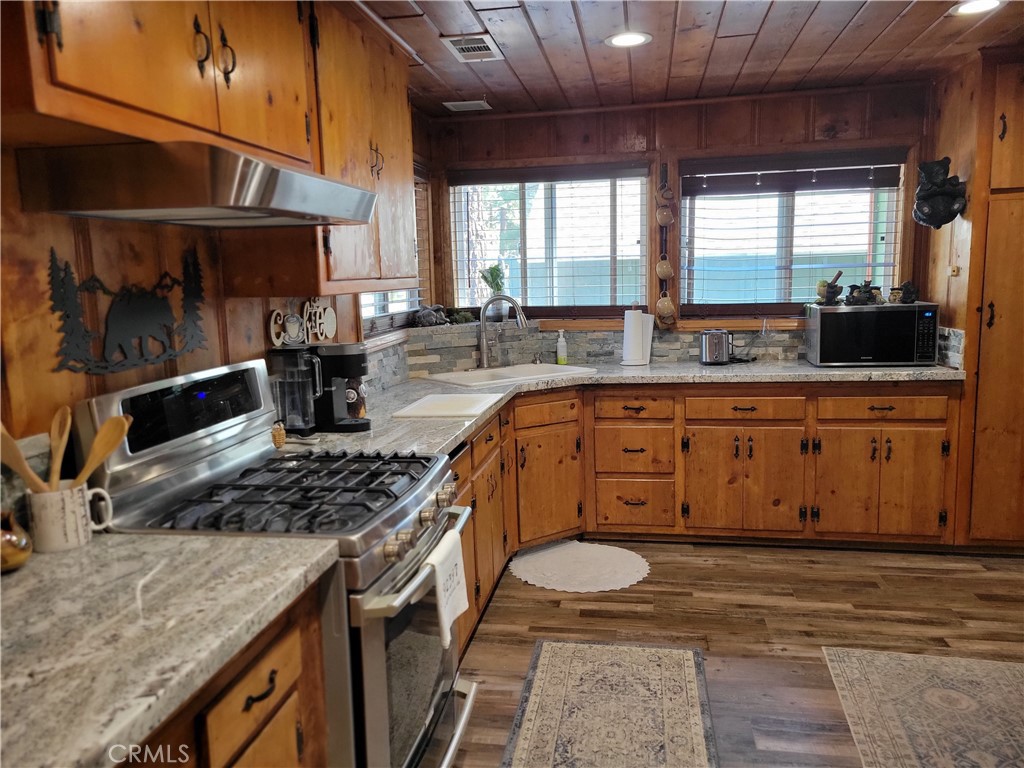 1116 Lark Road Wrightwood, CA 92397 - Photo 13 of 46 a kitchen with stainless steel appliances granite countertop a sink a stove and a wooden floors