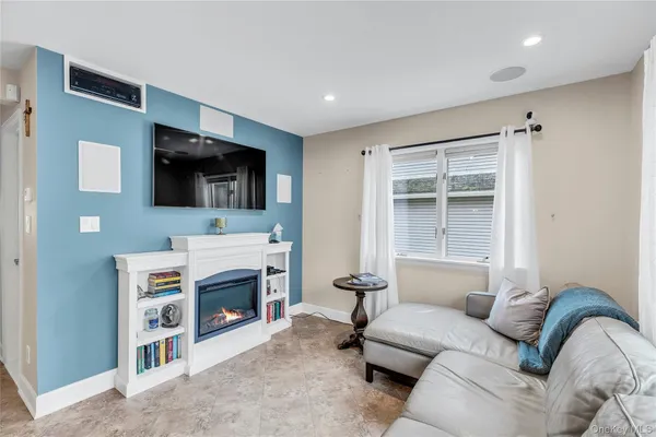 a living room with furniture a flat screen tv and a fireplace