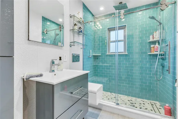 a bathroom with a sink mirror and shower