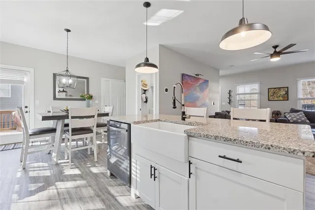a living room with granite countertop furniture a dining table chairs and a chandelier
