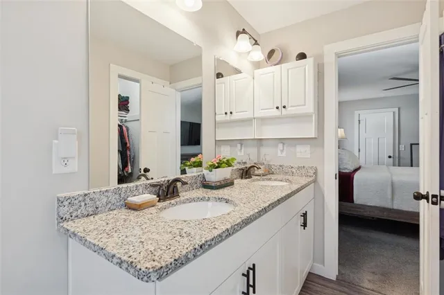 a bathroom with a granite countertop sink a toilet and shower