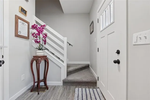 a view of a hallway with wooden floor and staircase