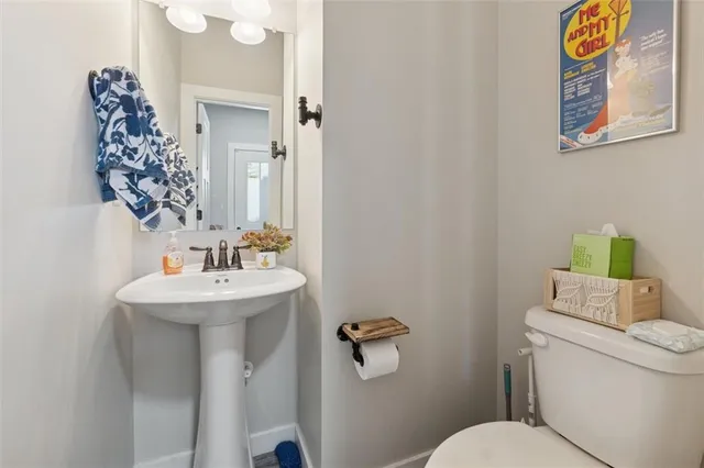 a bathroom with a toilet sink and mirror