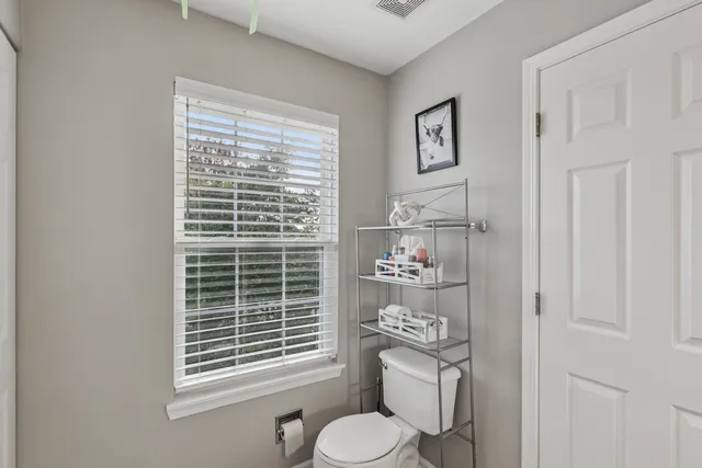 a bathroom with a toilet a sink and a window