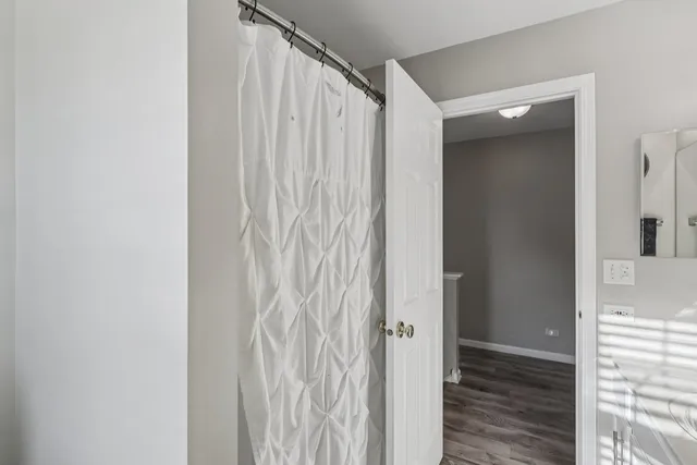 a view of a hallway with wooden floor and closet