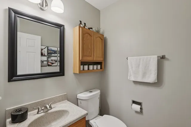 a bathroom with a toilet sink and mirror