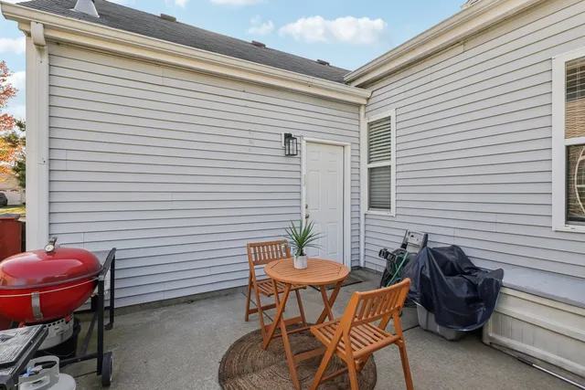 a patio with table and chairs and potted plants