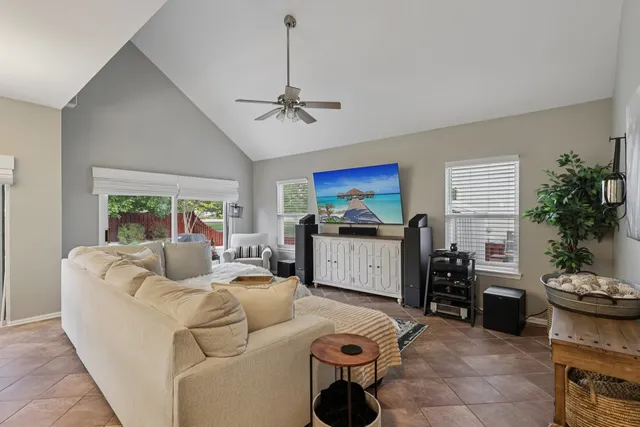 a living room with furniture a window and a flat screen tv