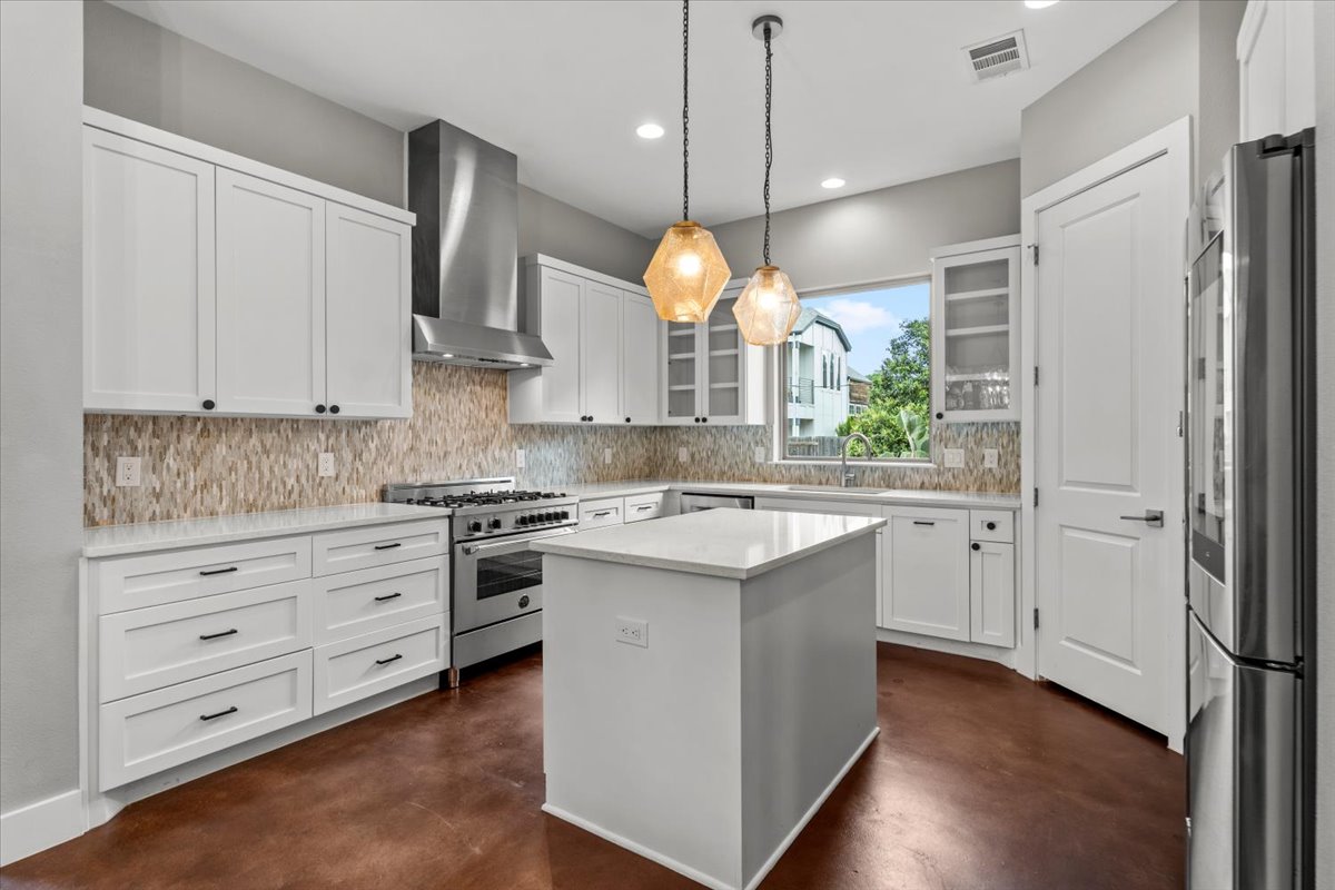 913 Stobaugh Street, Unit B Austin, TX 78757 - Photo 17 of 40 Culinary aspirations meet contemporary design in this kitchen, featuring stainless steel appliances and a central island.