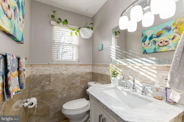 a bathroom with a granite countertop toilet sink and mirror