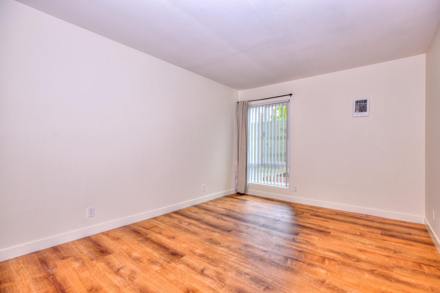 464 Dempsey Road, Unit 264 Milpitas, CA 95035 - Photo 12 of 16 a view of an empty room with wooden floor and a window