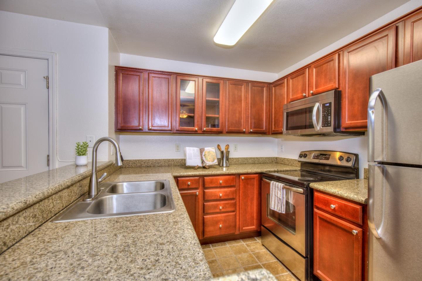464 Dempsey Road, Unit 264 Milpitas, CA 95035 - Photo 8 of 16 a kitchen with stainless steel appliances granite countertop a stove a sink dishwasher a refrigerator and a microwave