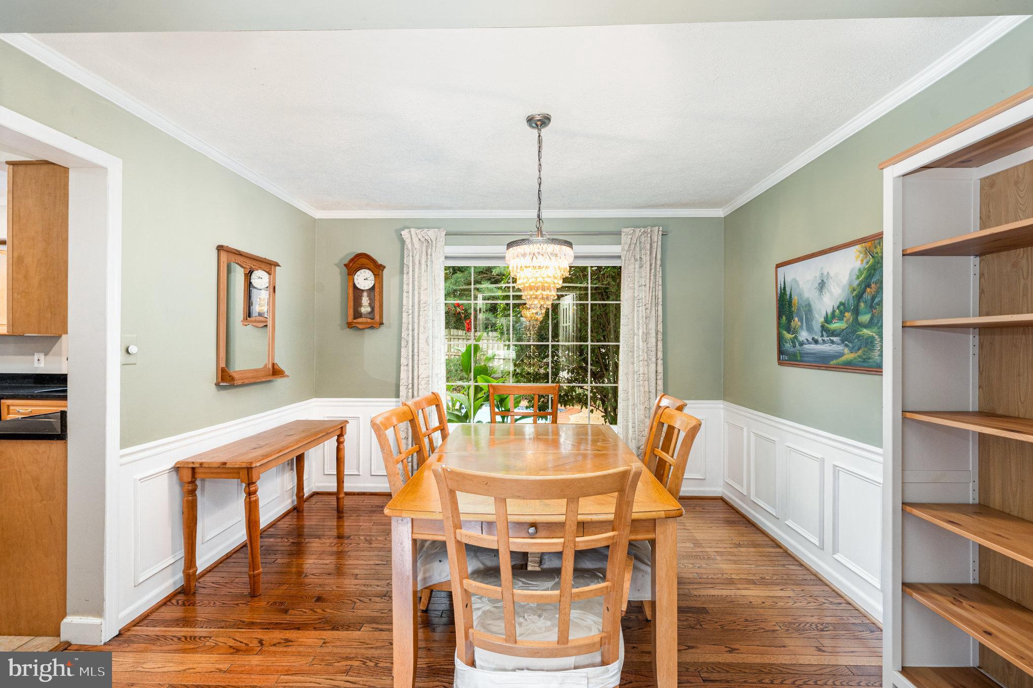4530 Rincon Place Dumfries, VA 22025 - Photo 8 of 45 a dining room with wooden floor a chandelier a glass table and chairs