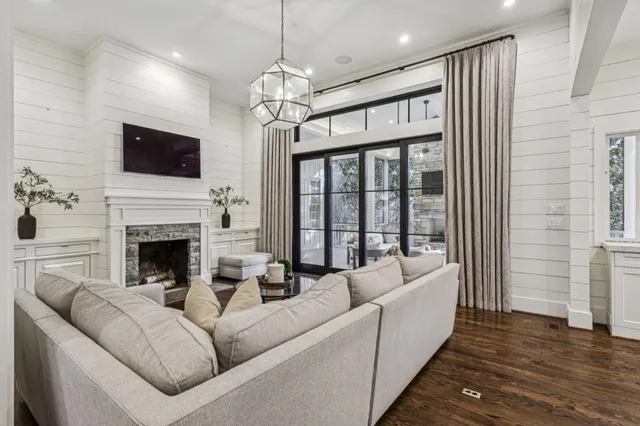 a living room with furniture kitchen view and a chandelier