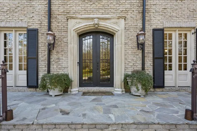 a dining room with wooden floor a chandelier a glass table and windows