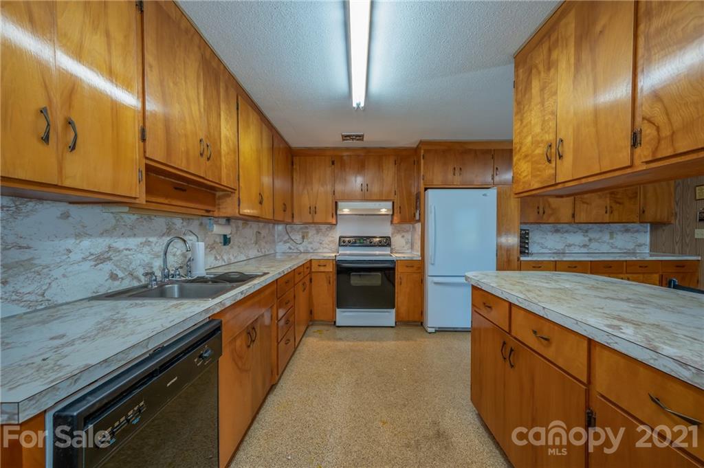 4771 Highway 9 Mill Spring, NC 28756 - Photo 10 of 35 a kitchen with stainless steel appliances granite countertop a sink a stove and a refrigerator