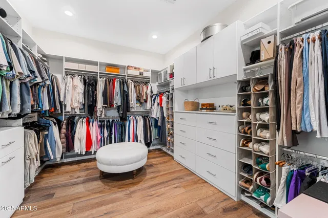a view of walk in closet with clothes and shoes