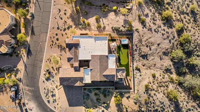 an aerial view of a residential apartment building with a swimming pool and mountains