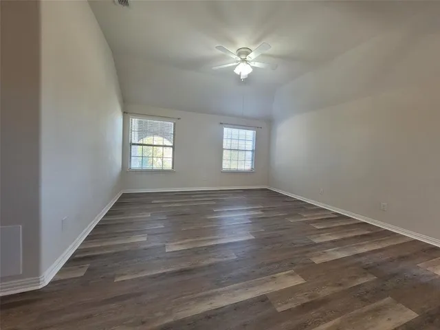 a view of empty room with window and ceiling fan