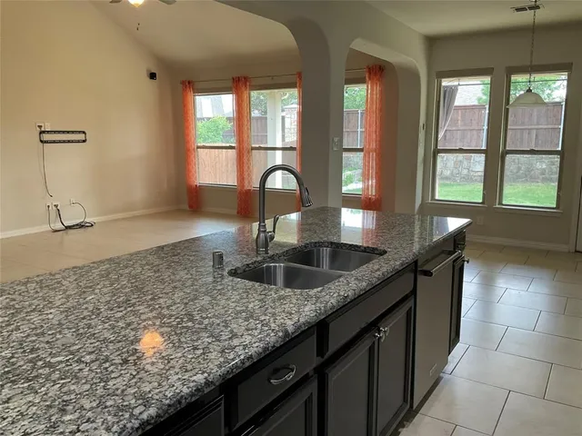 a kitchen with kitchen island granite countertop a sink stove and refrigerator