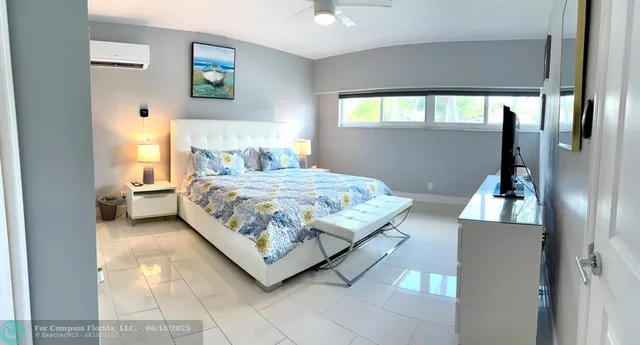 a spacious bedroom with a bed and a flat screen tv