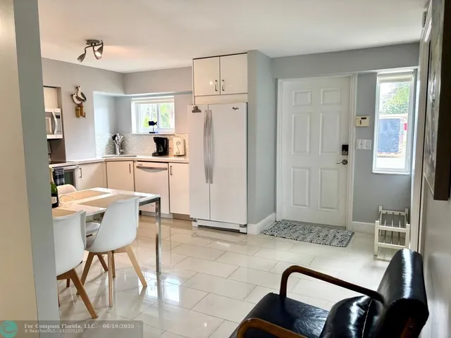 a living room with furniture and a refrigerator