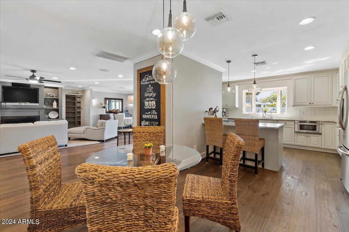 3841 East Elm Street Phoenix, AZ 85018 - Photo 19 of 72 a living room with kitchen island dining table wooden floor and a kitchen view