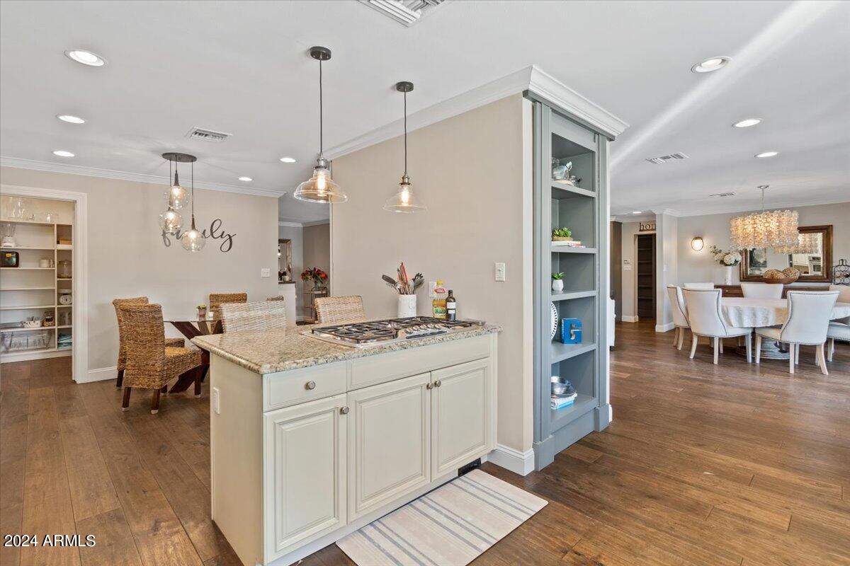 3841 East Elm Street Phoenix, AZ 85018 - Photo 21 of 72 a kitchen with stainless steel appliances kitchen island granite countertop a stove a sink a dining table and chairs with wooden floor