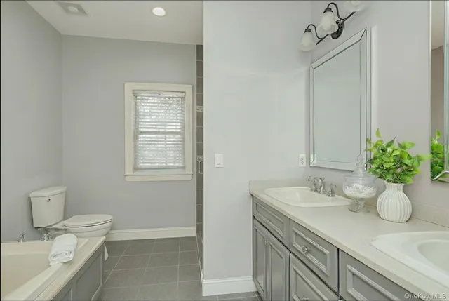 a bathroom with a granite countertop sink a toilet and mirror