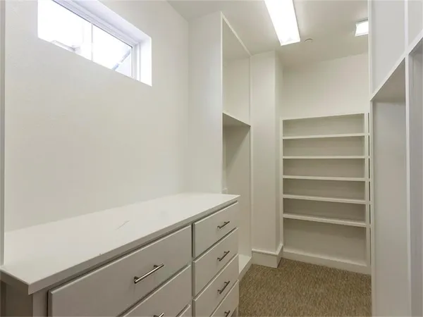 a view of walk in closet with empty racks