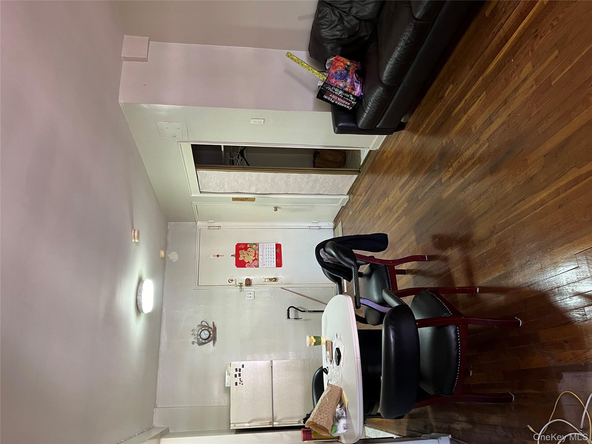 84-20 51st Avenue, Unit 6H Queens, NY 11373 - Photo 6 of 8 a living room with furniture and wooden floor