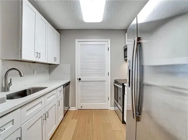 a kitchen with a refrigerator sink and cabinets