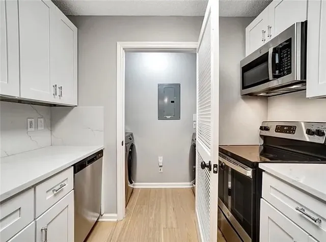 a kitchen with stainless steel appliances a sink dishwasher stove microwave and cabinets
