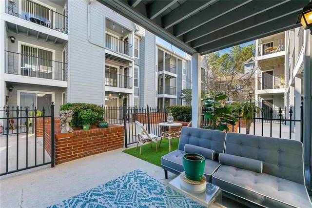 a view of a patio with couches chairs and wooden floor